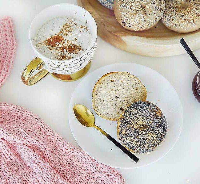 Enjoy these easy & delicious gluten free bagels with your Sunday morning latte! The best part is you absolutely can not tell they are gluten free. I promise! They are free from xanthan gum, guar gum & commercial yeast! These tasty bagels are traditional Canadian Montreal style, slightly sweeter (they are boiled in water sweetened with Canadian maple syrup or honey) and a little smaller smaller than New York style bagels. They are slightly crispy on the outside and chewy on the inside. These gluten free bakes are incredibly tasty with the perfect chewiness you've come to expect from a high quality bagel! If you're gluten free, dairy free, or vegan and miss eating bagels, you're going to love this recipe! Sourdough bagel recipe, gluten free sourdough bagels, gluten free vegan sourdough bagels, gluten free vegan, gluten free bagel recipe, gluten free bagels