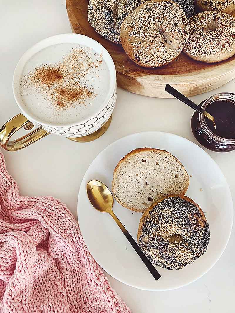 Enjoy these easy & delicious gluten free bagels with your Sunday morning latte! The best part is you absolutely can not tell they are gluten free. I promise! They are free from xanthan gum, guar gum & commercial yeast! These tasty bagels are traditional Canadian Montreal style, slightly sweeter (they are boiled in water sweetened with Canadian maple syrup or honey) and a little smaller smaller than New York style bagels. They are slightly crispy on the outside and chewy on the inside. These gluten free bakes are incredibly tasty with the perfect chewiness you've come to expect from a high quality bagel! If you're gluten free, dairy free, or vegan and miss eating bagels, you're going to love this recipe! Sourdough bagel recipe, gluten free sourdough bagels, gluten free vegan sourdough bagels, gluten free vegan, gluten free bagel recipe, gluten free bagels