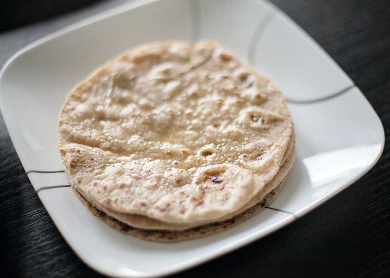 Roti is an Indian flatbread.  There are many ways to eat roti.  It can be paired with a curry or eaten on its own.  My kids love to have it with butter and honey spread on top.   It can be intimidating to make roti, but its really not too bad once you have made it a couple of times.  It's one of those things where practice makes perfect. Here I'll show you How to Make Roti with easy step by step instructions and photos.
