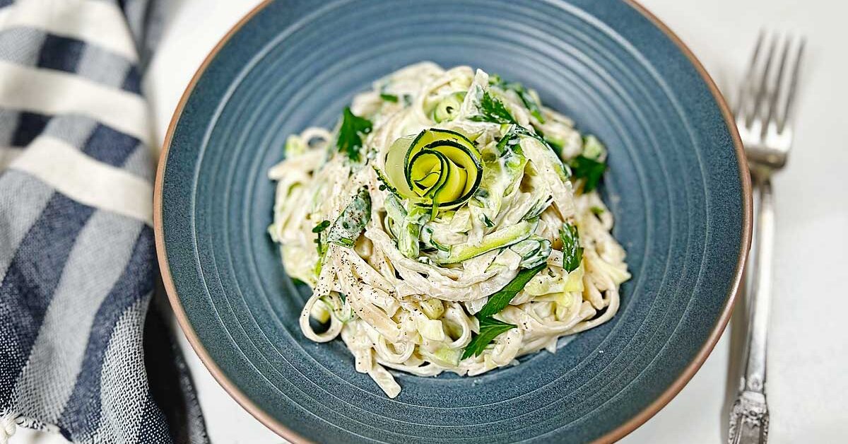 A Delicious Twist on a Classic Dish, this incredibly creamy Zucchini Alfredo is made with a mixture of gluten free pasta and Zucchini Noodles. Zucchini Noodles are a delicious & healthy way to use up your garden zucchini! Learn how to make zucchini noodles (zoodles) at home with our easy step-by-step guide. Discover the best methods for creating zucchini noodles without a spiralizer, cooking, and seasoning zucchini to create a satisfying low-carb alternative to pasta dishes. #Zucchini noodles, Zoodles, Spiralizer, Gluten-free pasta, Low-carb recipes, Healthy eating, Veggie noodles, Cooking with zucchini, Zucchini recipes, Spiralized vegetables, Zucchini pasta, Homemade zoodles, Spiralizing tutorial, Quick and easy meals, Low-calorie pasta alternative, Zucchini noodle dishes, Cooking techniques, Kitchen gadgets, Healthy meal ideas, Nutrient-rich meals, fettuccine Alfredo, Alfredo Sauce